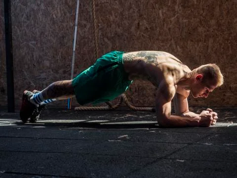 Young man in gym doing exercises for abs. Stock Photos