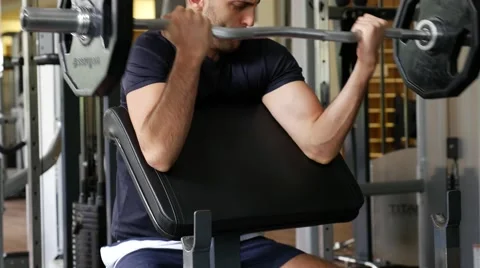 Young man in the gym, exercise for the biceps Stock Footage 65818096