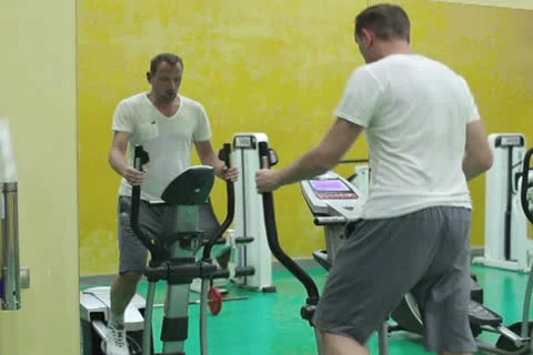 Young man at the gym exercising on the xtrainer machines Stock Footage 24960039