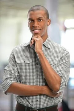 Young man with hand on chin Stock Photos