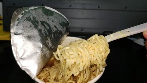 Young man hand holding plastic fork of instant noodles Stock Footage 115118213