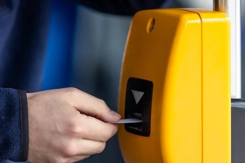 Young man hand inserts the bus ticket into the validator, validating and ticking Stock Photos