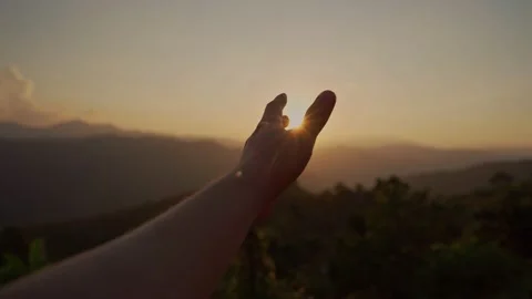 Young man hand reaching for the mountains during sunset Видео 168279147