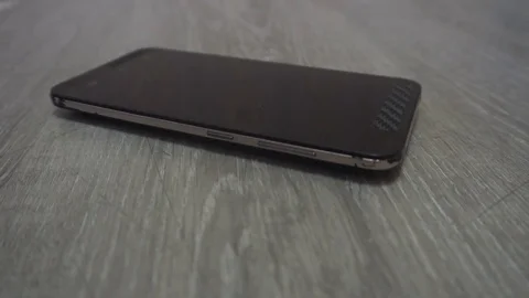 Young man hand takes mobile phone from grey background Stock Footage 83630108