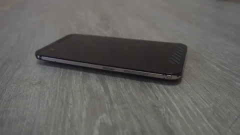 Young man hand takes mobile phone from grey background Stock Footage 83630603
