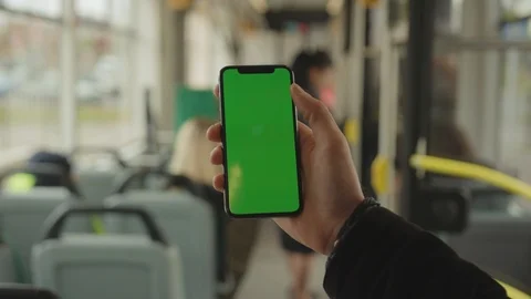 Young man hand uses holding a mobile telephone with a vertical green screen Stock Footage 117942040