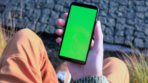 Young man hand using smartphone with blank green screen. Sunset sunlight rising 스톡 동영상 165118539