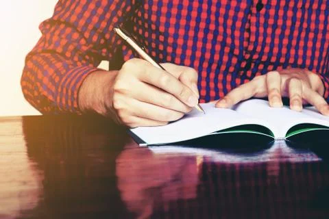 Young man hand writing on notebook with pen. Stock Photos