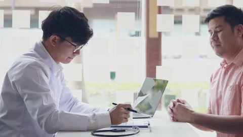 Young man handed the document to the man in the white coat, patient has submi Stock Footage 154261244