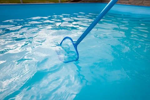 Young man hands cleaning pool by net of the dust, maintenance, clearing swimming Фото