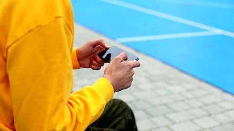 Young man hands using smart phone for playing game online on modern sport area 스톡 동영상 135679942