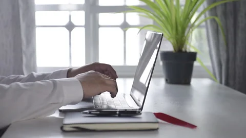 Young man hands working on his laptop - Man working at home with a window beh Stock Footage 163895994