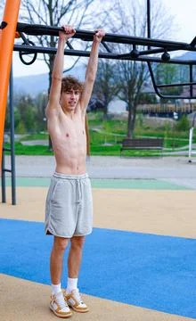 Young man hanging on monkey bars outdoors Stock Photos