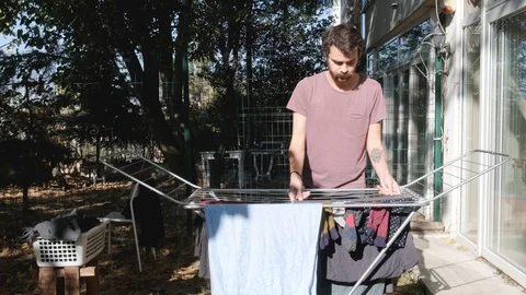 Young Man Hangs Laundry In The Garden Stock Footage 119155194
