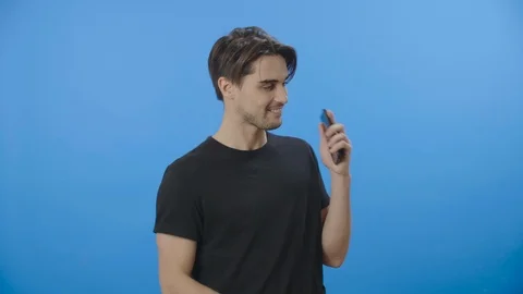 Young man happily dancing while listening to music from his phone - 4K Stock Footage 88399395