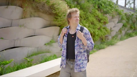 A young man is happily texting on his smartphone while casually walking through Stock Footage 281608844