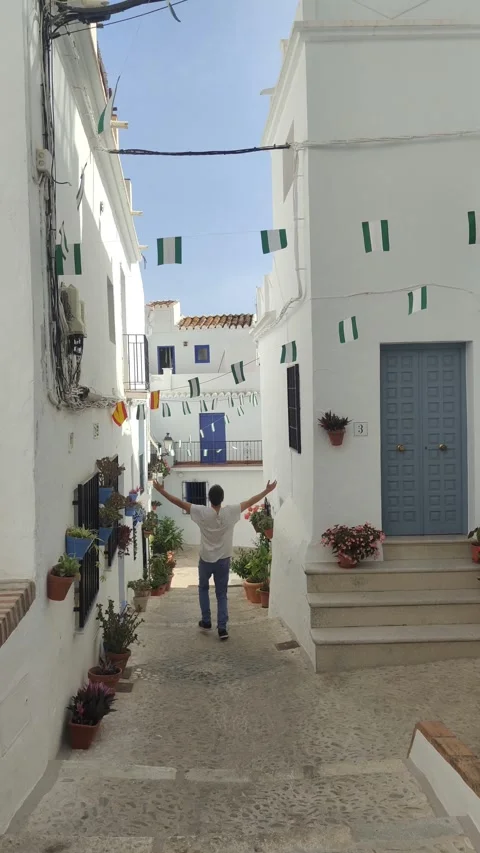 Young man happily walking down charming european street Stock Footage 344692251