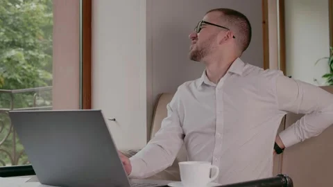 A young man has a backache at a sedentary job Stock Footage 159900077