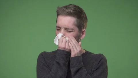 Young man has caught cold and using handkerchief for his runny nose Stock Footage 73239757