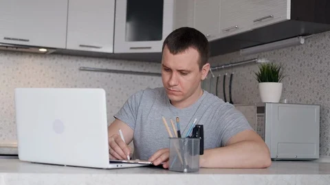 A young man has difficulty working remotely from home and holds his hands behind Stock Footage 127604502