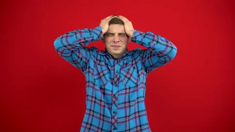 A young man has a headache and holds it in his hands. Shooting on a red Stock Footage 147395031