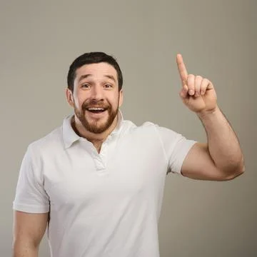 Young man has idea, pointing with finger up isolated on gray background. Foto stock