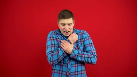 A young man has a sore arm. The man touches the sore hand. Shooting on a red Stock Footage 147394809