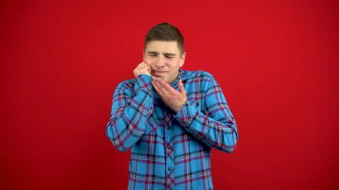 The young man has a toothache and touches his cheek with his hand. Shooting on a Stock Footage 147395811