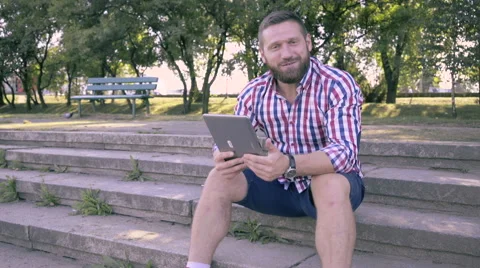 Young man has video conversation by tablet and looks for camera. 库存影片 67242640