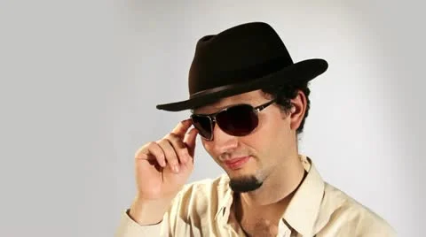 A young man in a hat and glasses flirts Vídeos de archivo 11007023