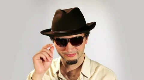 A young man in a hat and glasses flirts Stock Footage 11007243