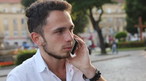 Young man have a serious talk on cellphone in the city center. Male in his 20s Stock Footage 62312559