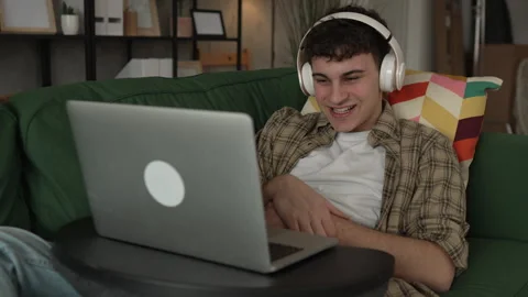 Young man have video call use laptop computer and headphones at home Stock Footage 268755891