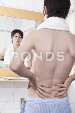 Young man having back pain Stock Photos
