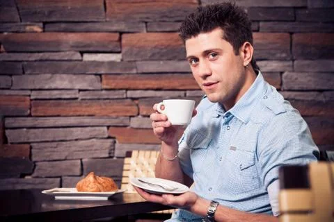 Young Man Having Breakfast In A Cafe Photos