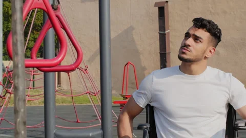 Young man having disability rides wheelchair using hands on stadium. Persistent Stock Footage 166339745