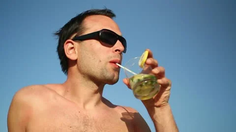 Young man having a drink against blue sky HD Stock Footage 10888356