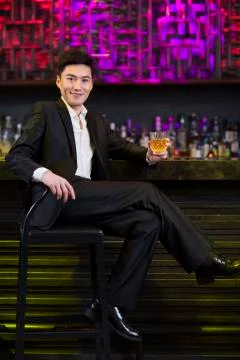 Young man having a drink at bar Stock-Fotos