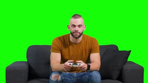 Young man having fun playing video games sitting on sofa Stock Footage 136369985