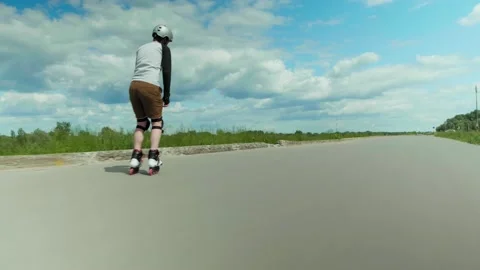 Young man having fun roller skating alone on a road on a sunny day Self distance Video stock 132798631