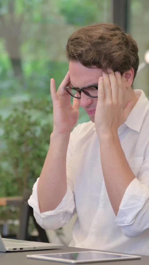 Young Man having Headache while Working on Laptop in Modern Office, Vertical Stock Footage 340038616
