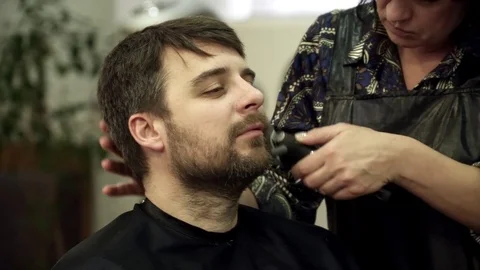 Young man is having his beard cut in salon, closeup Stock Footage 73821274