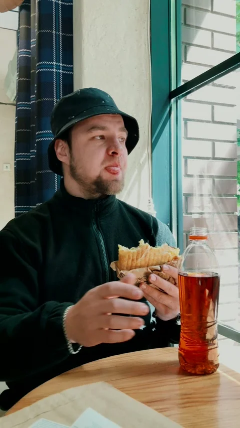 Young man having lunch with a sandwich. takes a break from work. Stock Footage 284482900