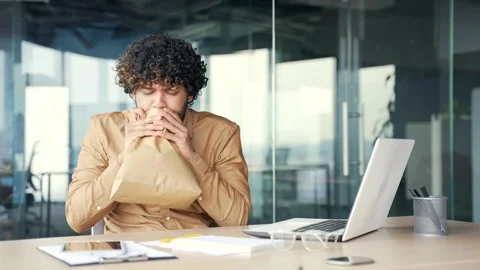 A young man having a panic attack while working on a laptop while sitting at  Stock Footage 244007129