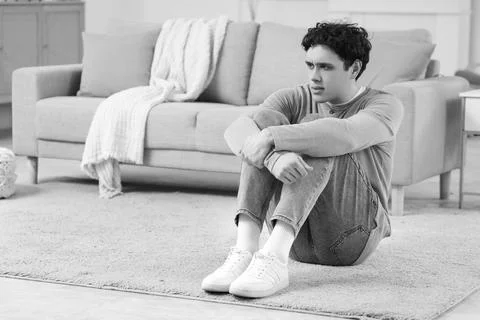 Young man having panic attack on floor at home Stock Photos