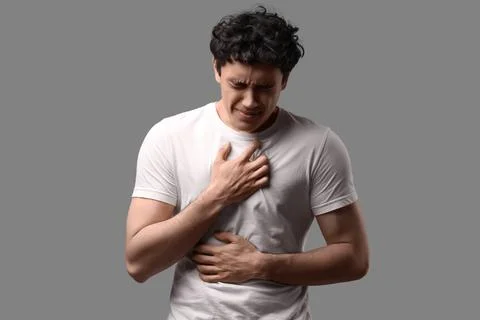 Young man having panic attack on grey background Stock Photos