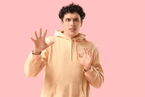 Young man having panic attack on pink background Stock Photos