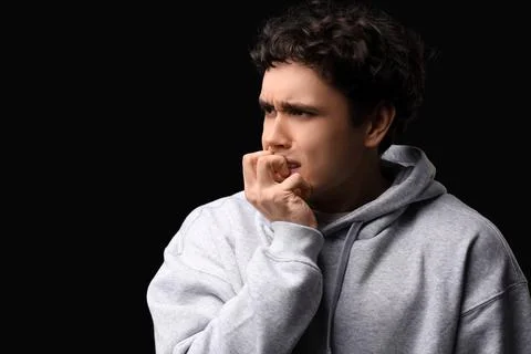 Young man having panic attack on black background Stock Photos