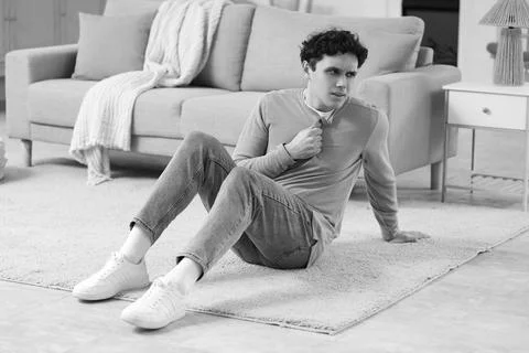 Young man having panic attack on floor at home Stock Photos
