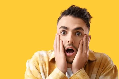 Young man having panic attack on yellow background, closeup Stock Photos